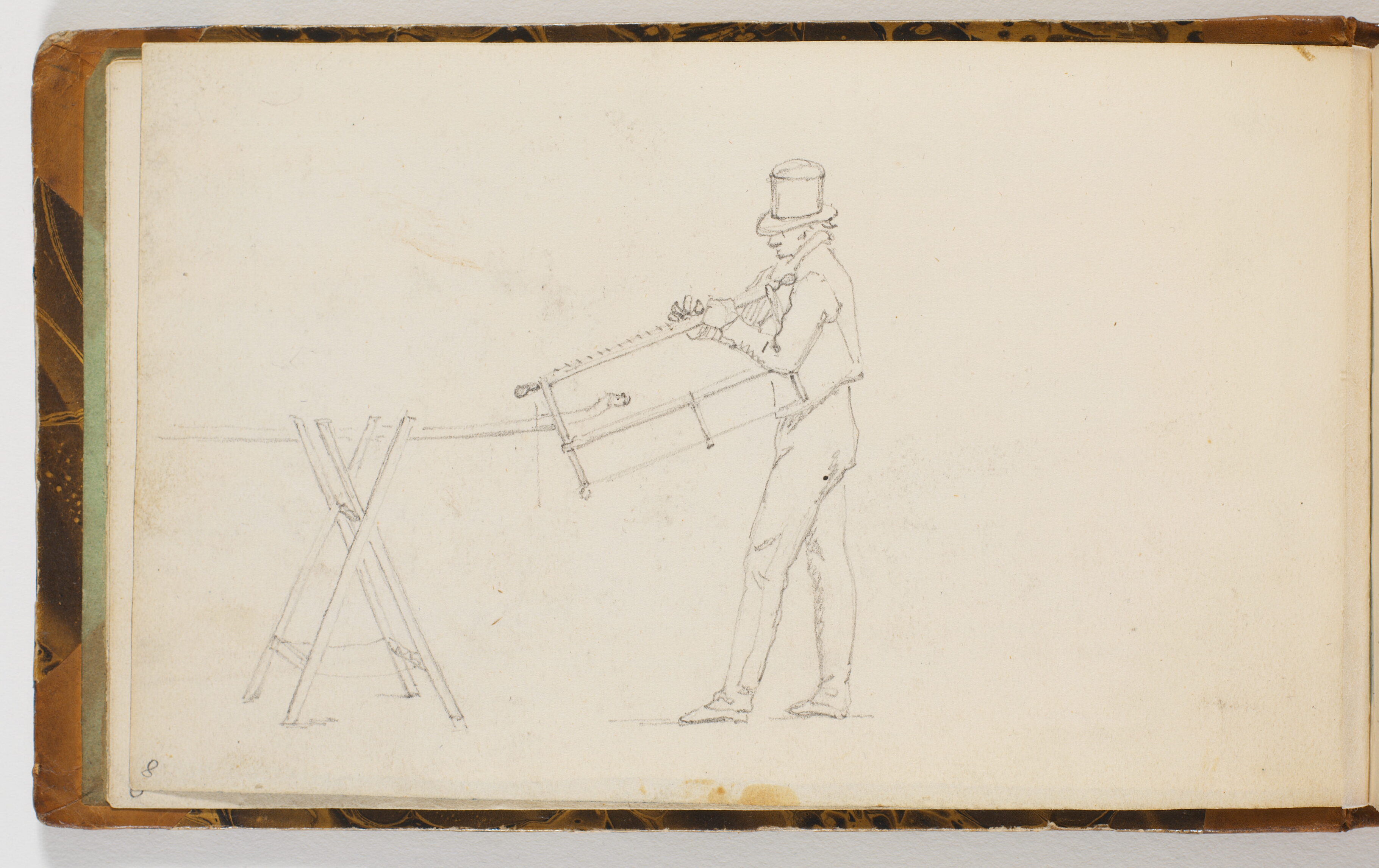 Mand ved en savbuk, holdende en sav